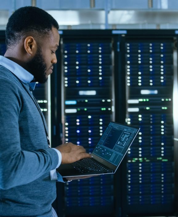 Black,Data,Center,It,Technician,Walking,Through,Server,Rack,Corridor